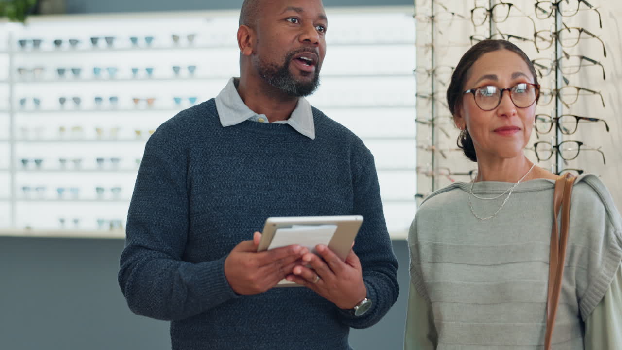 Optician helping customer choose eyeglasses