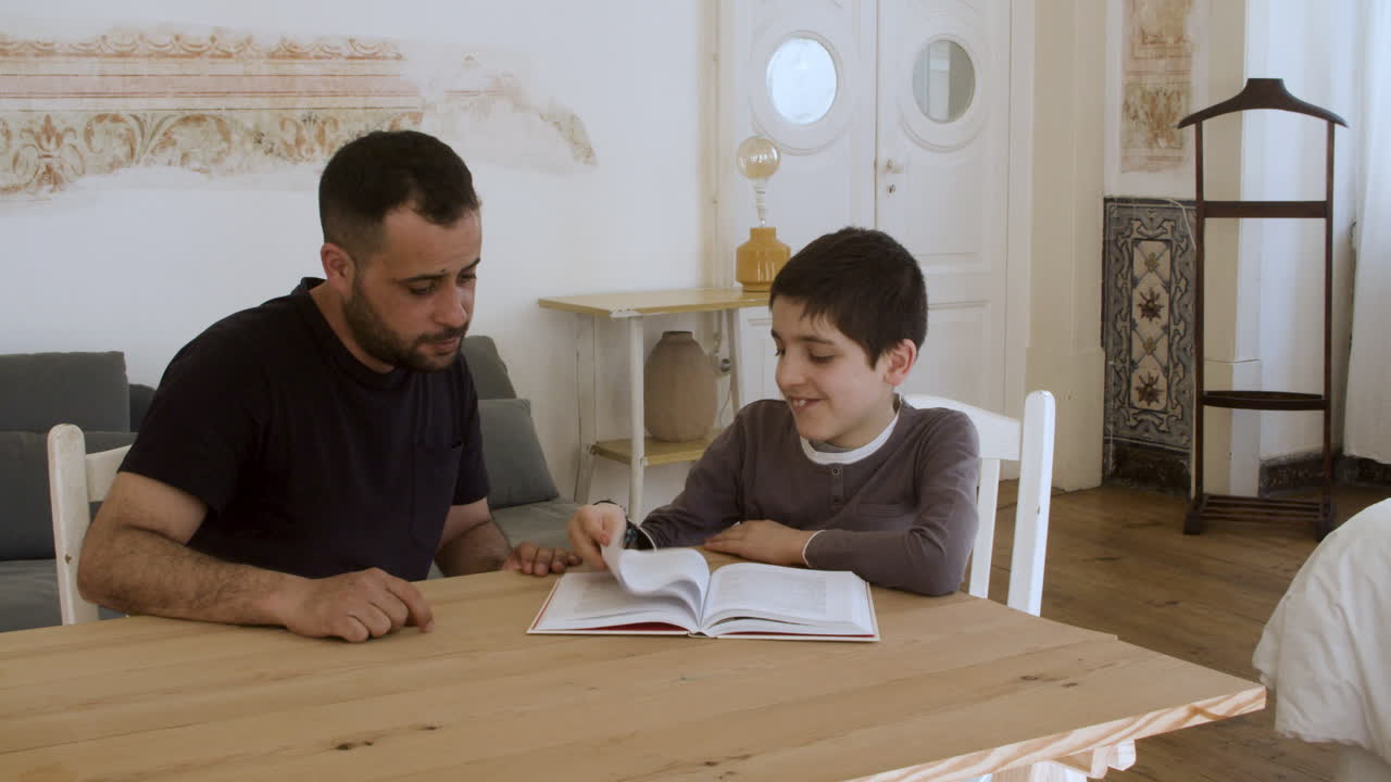 hijo y padre leyendo un libro juntos.