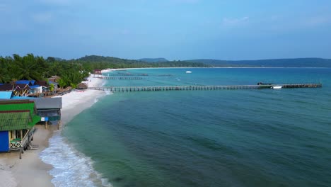 colorful bungalows rising on a tropical beach in koh rong island, cambodia. magic aerial view flight descending drone