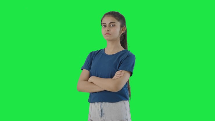 retrato de una adolescente india confiada de pie con las manos cruzadas pantalla verde