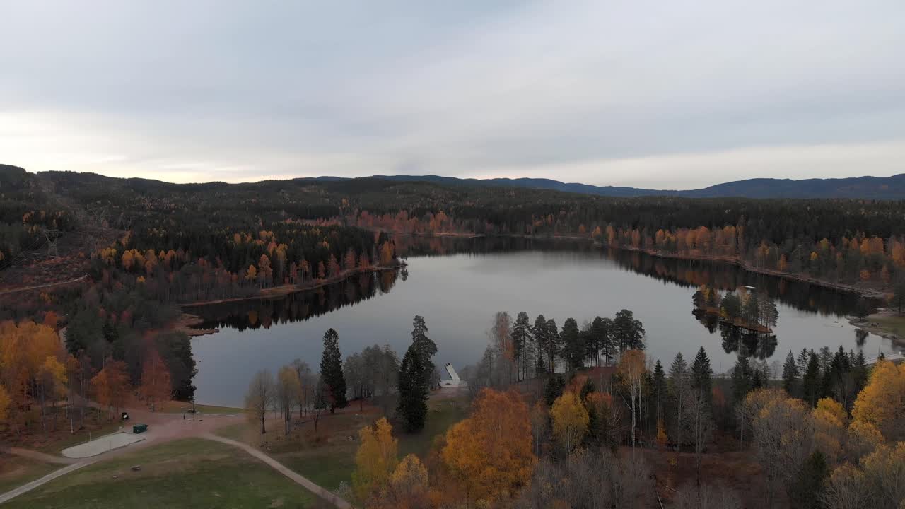 Slow forward aerial shot of a small Norwegian lake in the fall