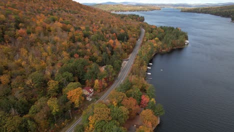 costa del lago sunapee en otoño, vista aérea de follaje colorido, autos en la carretera y casas frente al lago, disparo de drones