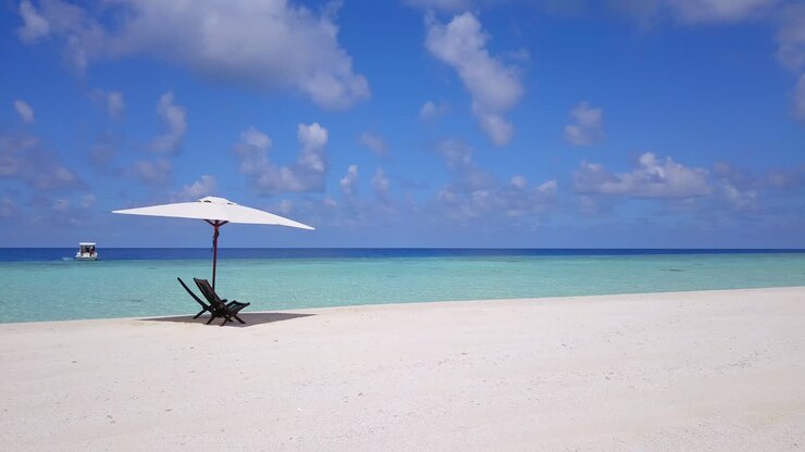 due sedie di legno sotto un ombrellone bianco sulle spiagge di sabbia bianca di un tropicale è