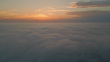 orange cloudy sky horizon aerial view. golden skyline over white fluffy clouds