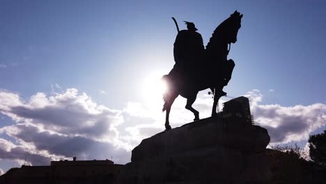 silhouette of horseman on the horse riding. statue of sheshi skenderbej in tirana center. camera movement