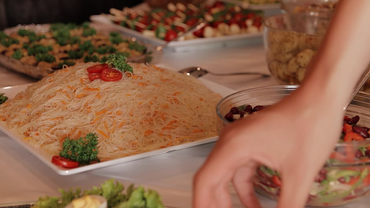 una niña elige una comida buffet diferente con muchas ensaladas diferentes