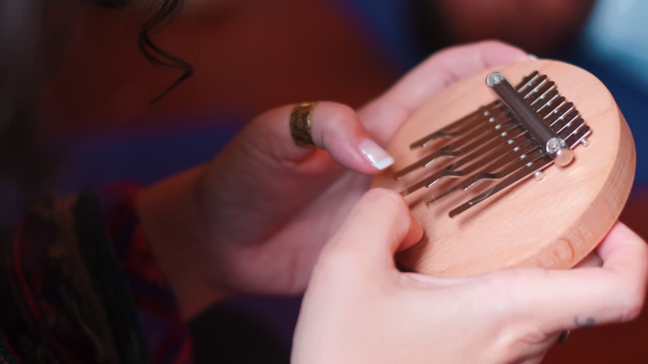 primer plano de una mujer tocando el instrumento kalimba durante el día soleado en la isla de madeira, portugal