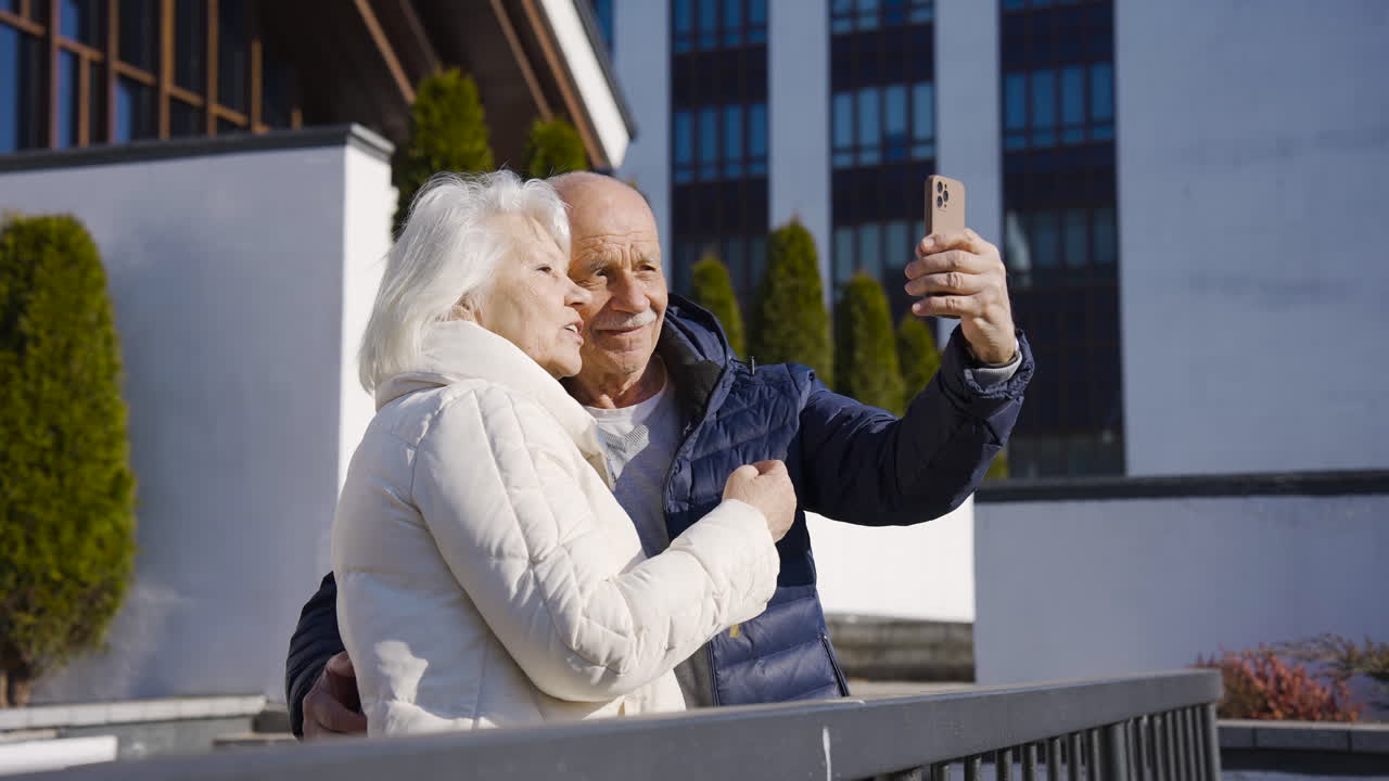 pareja mayor haciendo un selfie con smartphone en el parque en un día de invierno