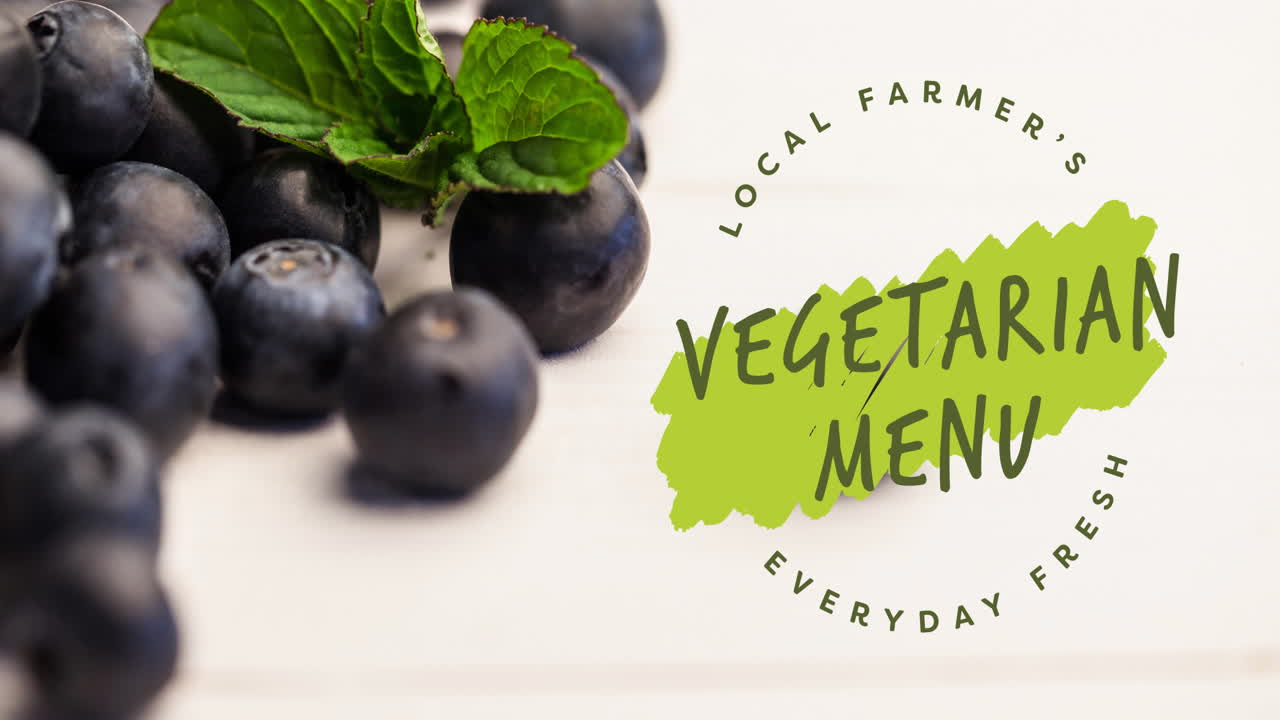 Animation af teksten "vegetarisk menu" i grønt over friske økologiske blåbær