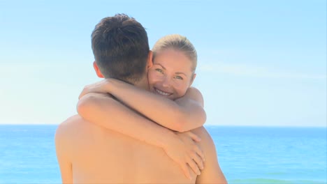 attractive woman hugging boyfriend on a beach