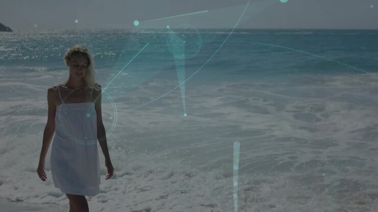 Vertical video: Walking woman in white dress nearing camera on shore, sun making overlays, modeling
