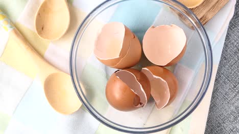 eggshells in a white  bowl on table ,