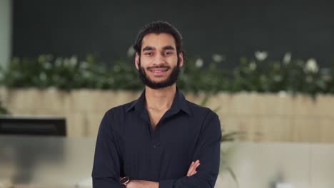 close up portrait of arab guy office worker folding arms and looking at camera smiling