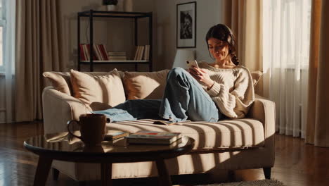 woman relaxing on couch using smartphone