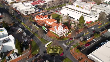 Atemberaubende-Luftaufnahmen-Des-Gebäudes-Des-Informationszentrums-In-Der-Stadt-Rotorua-Und-Des-Verkehrs-Im-Kreisverkehr