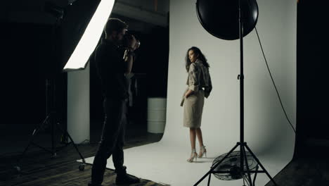 african american female model posing to the camera of the man photographer in the studio with spotlight