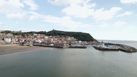 Aerial-approach-view-of-Scarborough-town,-beach,-harbor-and-castle