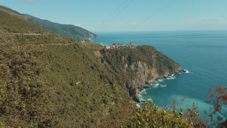 Cinque-Terre-Corniglia-reveal-shot-of-the-coast,-clouds,-horizon,-vacation,-blue,-sky,-Italy,-vegetation,-grass,-plants,-trees,-green,-aquamarine,-tranquility,-foam