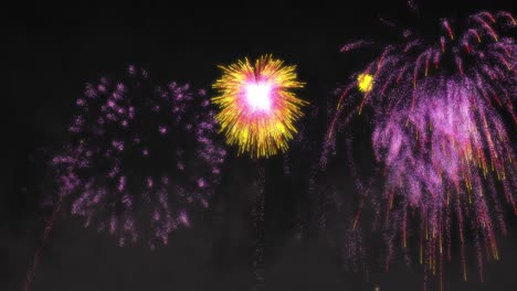 animation of yellow and pink fireworks exploding on black background