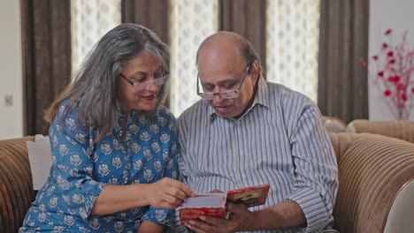 Feliz-Pareja-De-Ancianos-Indios-Revisando-El-álbum-De-Fotos