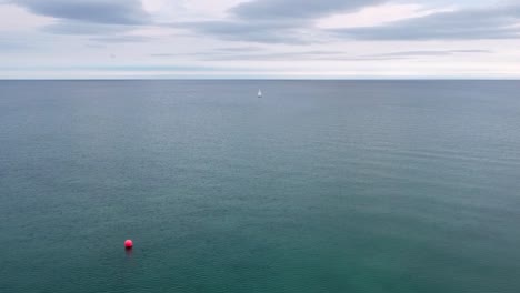 Velero-Solitario-Y-Boya-Roja-En-Agua-Dulce-Azul-Turquesa-Clara-Y-Hermosa