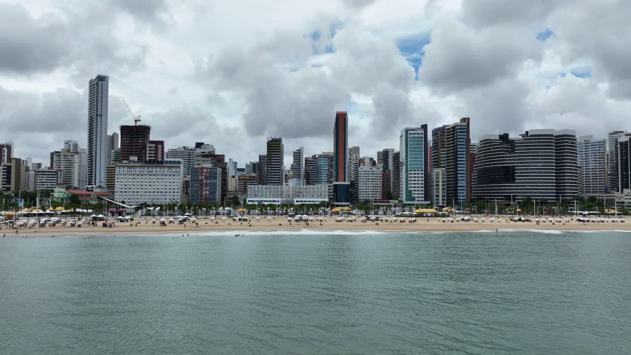 Fortaleza beach view showcasing sandy shore, towering skyscrapers, and vibrant cityscape.