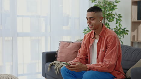 man texting on smartphone at home