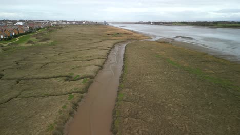 salt marsh tributary with distant shipwrecks at fleetwood marshes nature reserve