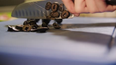 slicing black olives on a cutting board