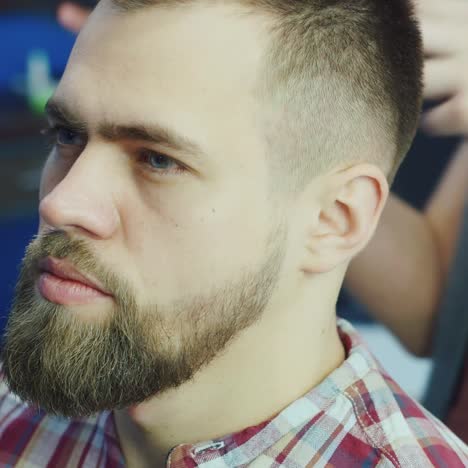 caucasian man getting hair blow-dried in barbershop