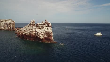 Aerial-drone-shot-of-"La-Lobera"-with-some-boats-in-the-Partida-Island,-Baja-California-Sur