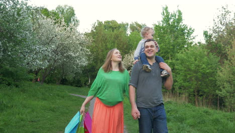 familia feliz caminando en el parque después de las compras