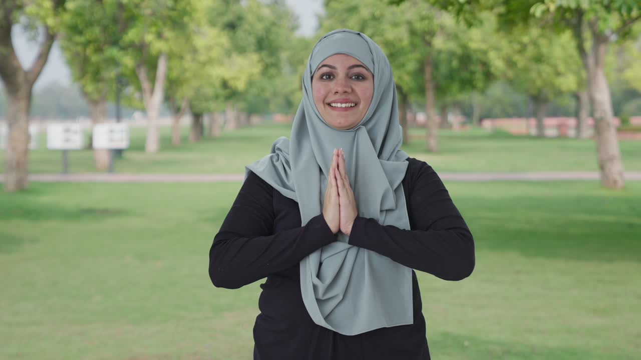 Mutlu Müslüman kadın parkta Namaste yapıyor.