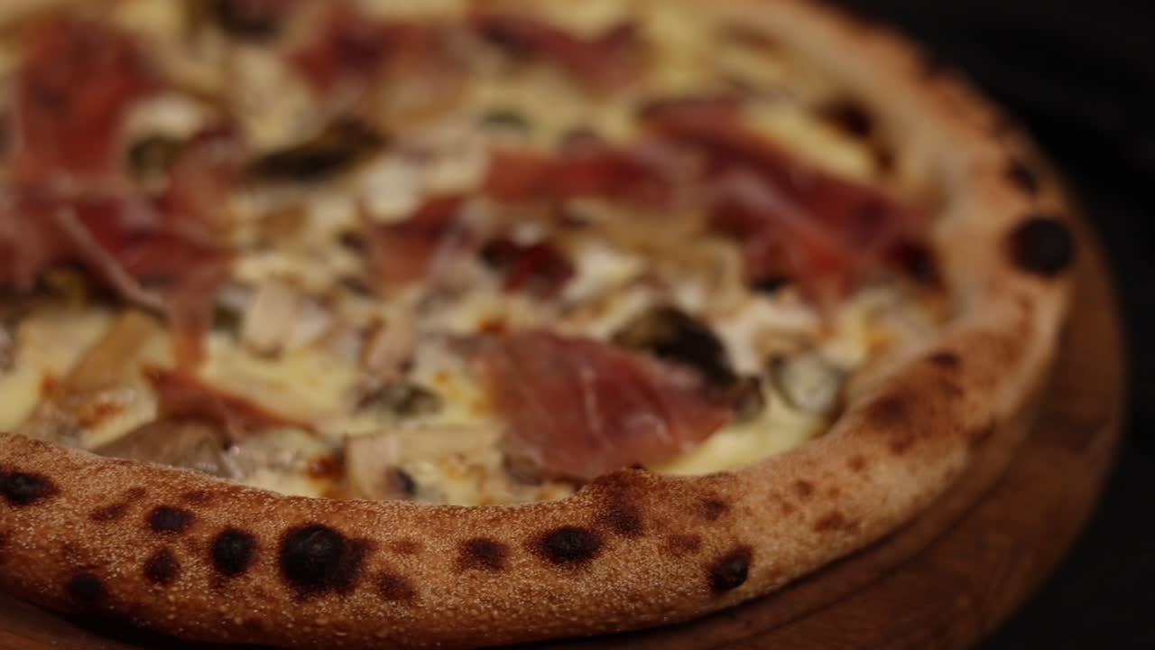 Primo piano di una deliziosa pizza con funghi e prosciutto.