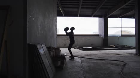 African-american-man-exercising-with-medicine-ball-in-an-empty-urban-building