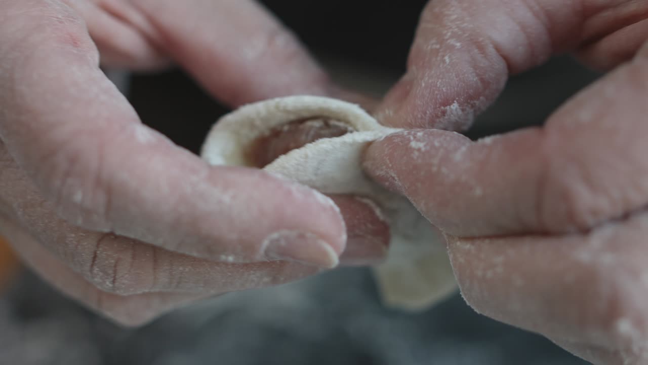 dos manos haciendo albóndigas de carne.