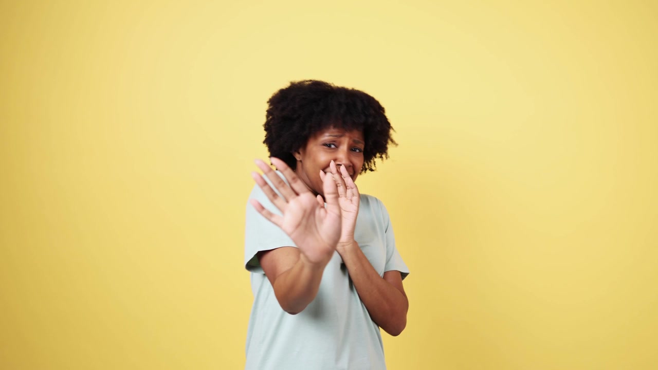 Young Black Woman Expressing Fear and Warding Off with Hands