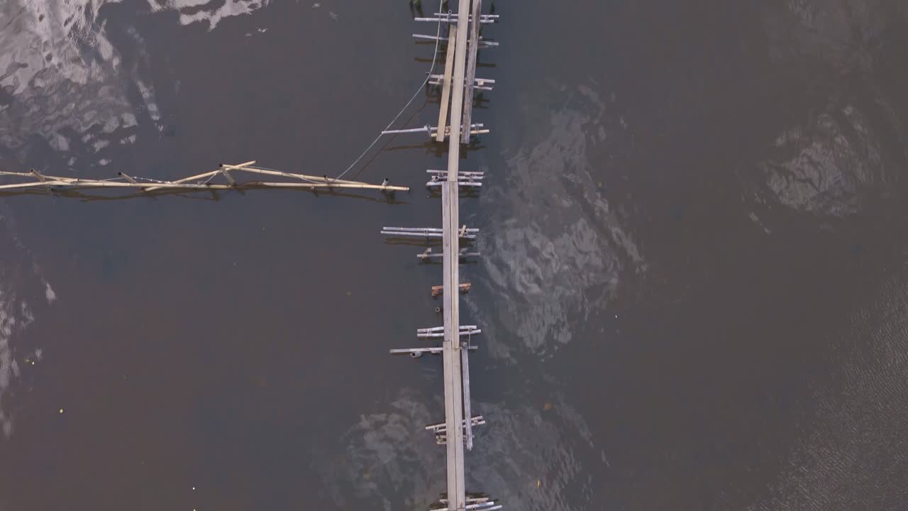 Aerial View of a Wooden Bridge and Houses Over Water in a Remote Village