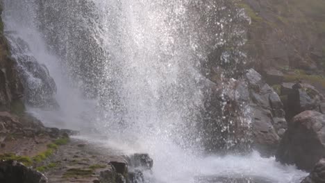 Closeup-on-drops-of-water-in-backlight-at-Waterfall-of-Vallesinella-and-landscape,-Madonna-di-Campiglio,-Trentino-Alto-Adige,-Italy