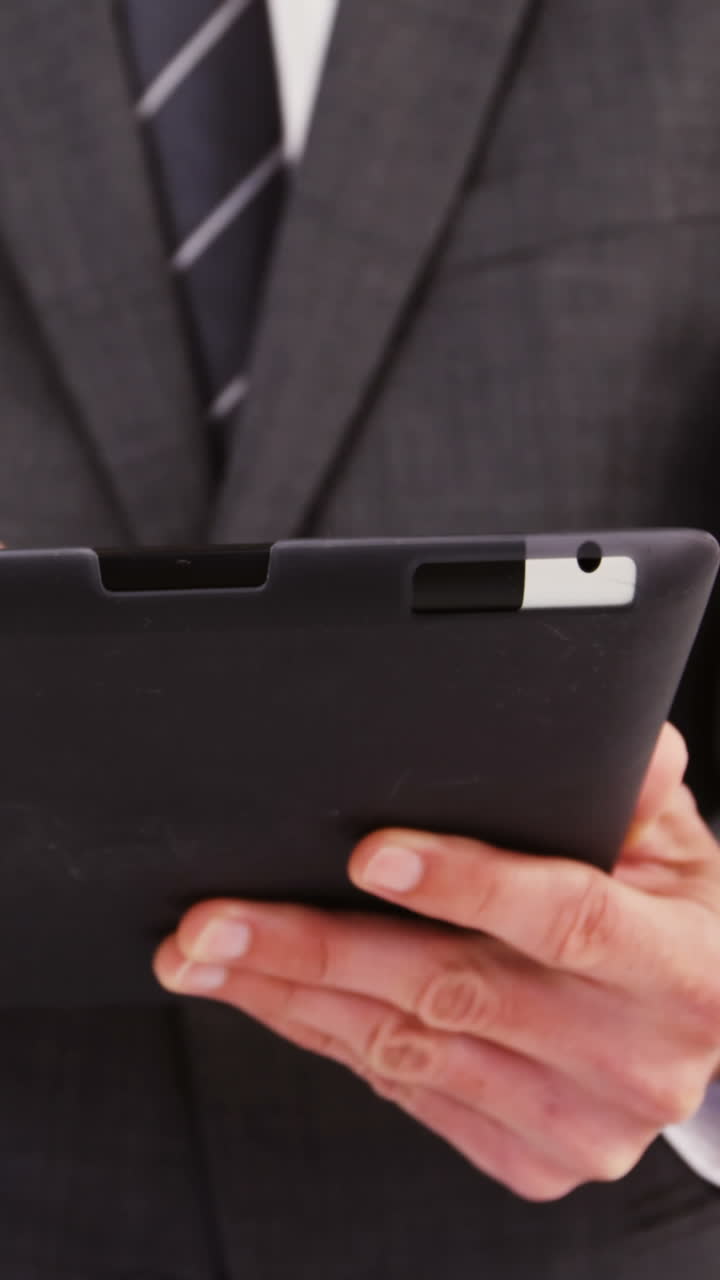 Mid-section of businessman using digital tablet