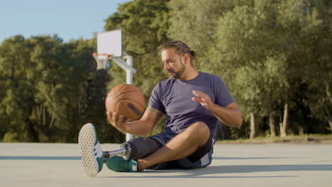 Bearded-middle-aged-man-with-leg-prosthesis-sitting