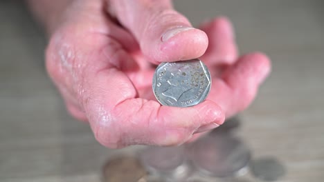 old man twists a coin from his native venezuela he fled