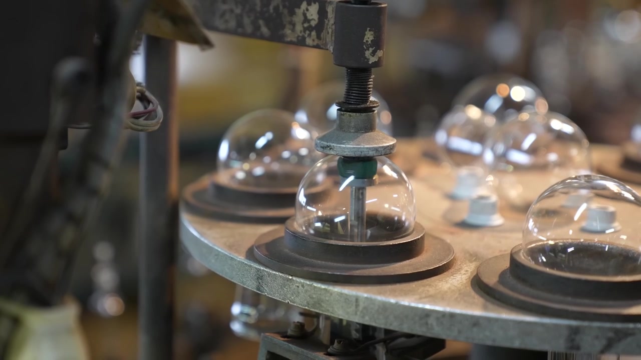 Rotary carousel machine holding clear glass bulb domes ready for processing