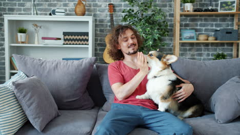 man and his corgi on the sofa