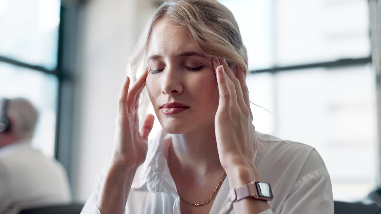 Businesswoman experiencing headache in office