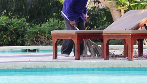 person tidying up pool chairs methodically