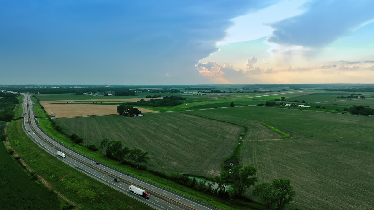 Busy highways crossing the green fields in the countryside. Aerial perspective on the beautiful farms located far from each other.
