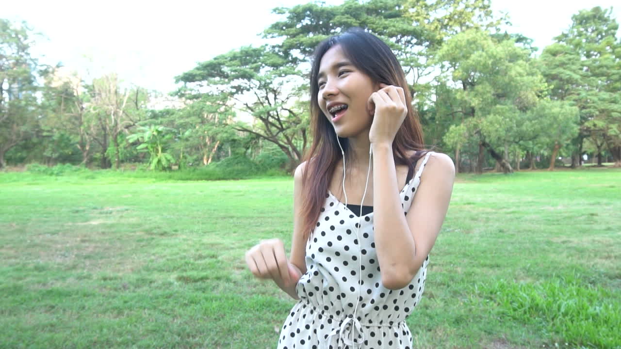 귀여운 여자가 음악 비트에 따라 듣고 춤을 춘다.