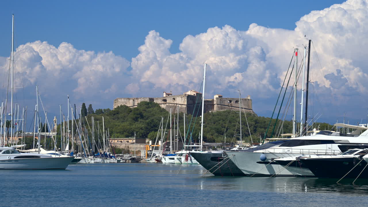 Boats docked in the Port Vauban with the Fort Carre on the background in Antibes, France