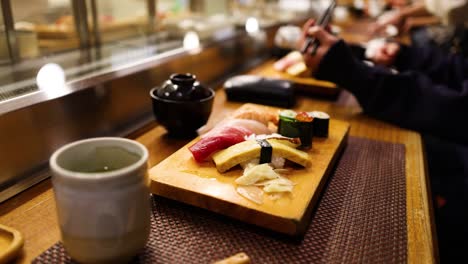 gente compartiendo comida de sushi, ambiente acogedor, risas